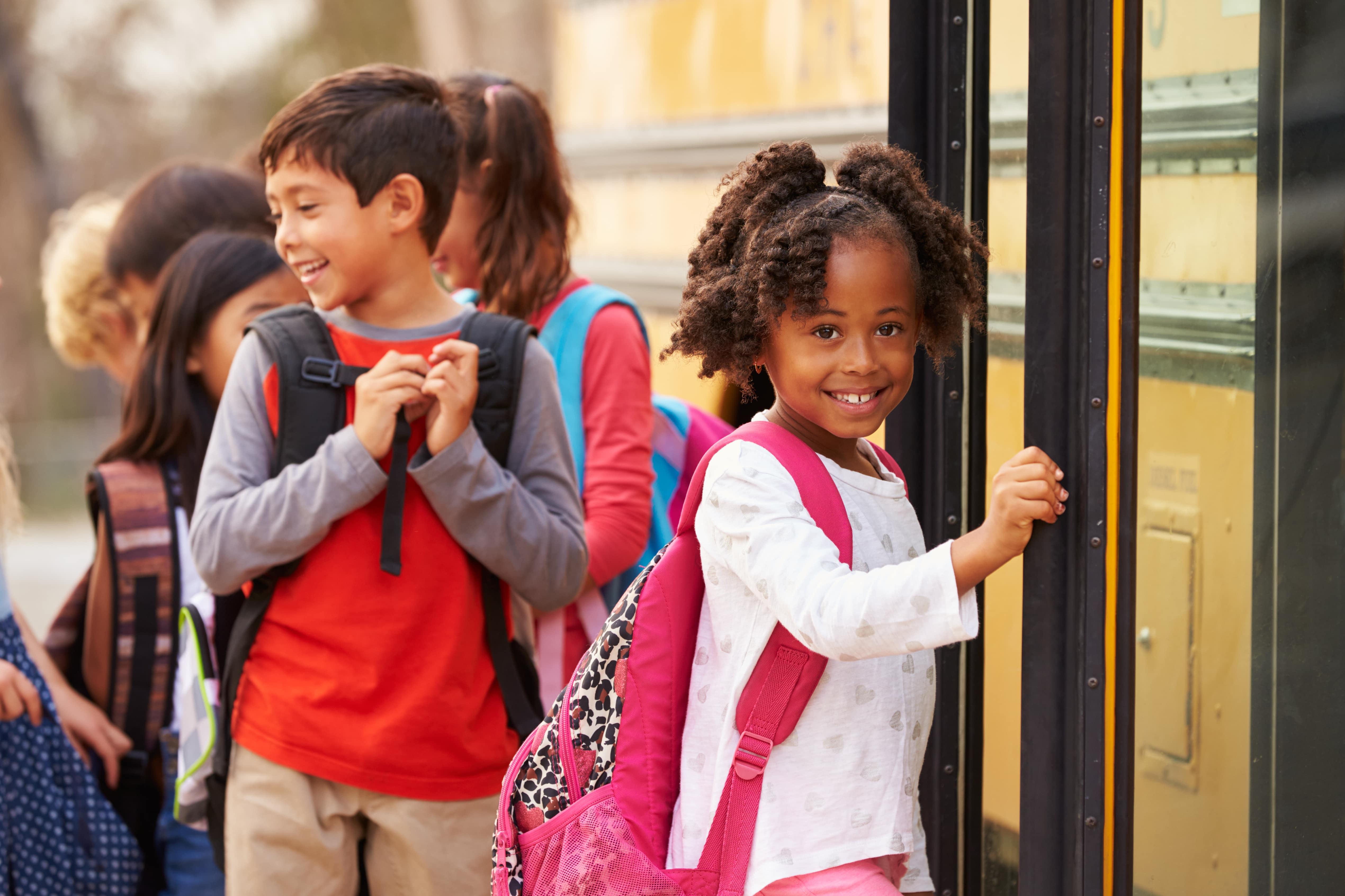 Schulkinder, die in einen Bus einsteigen